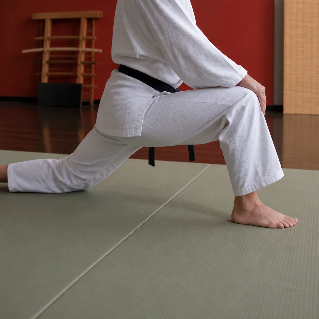 a practitioner in a deep lunge stretch on a mat before training